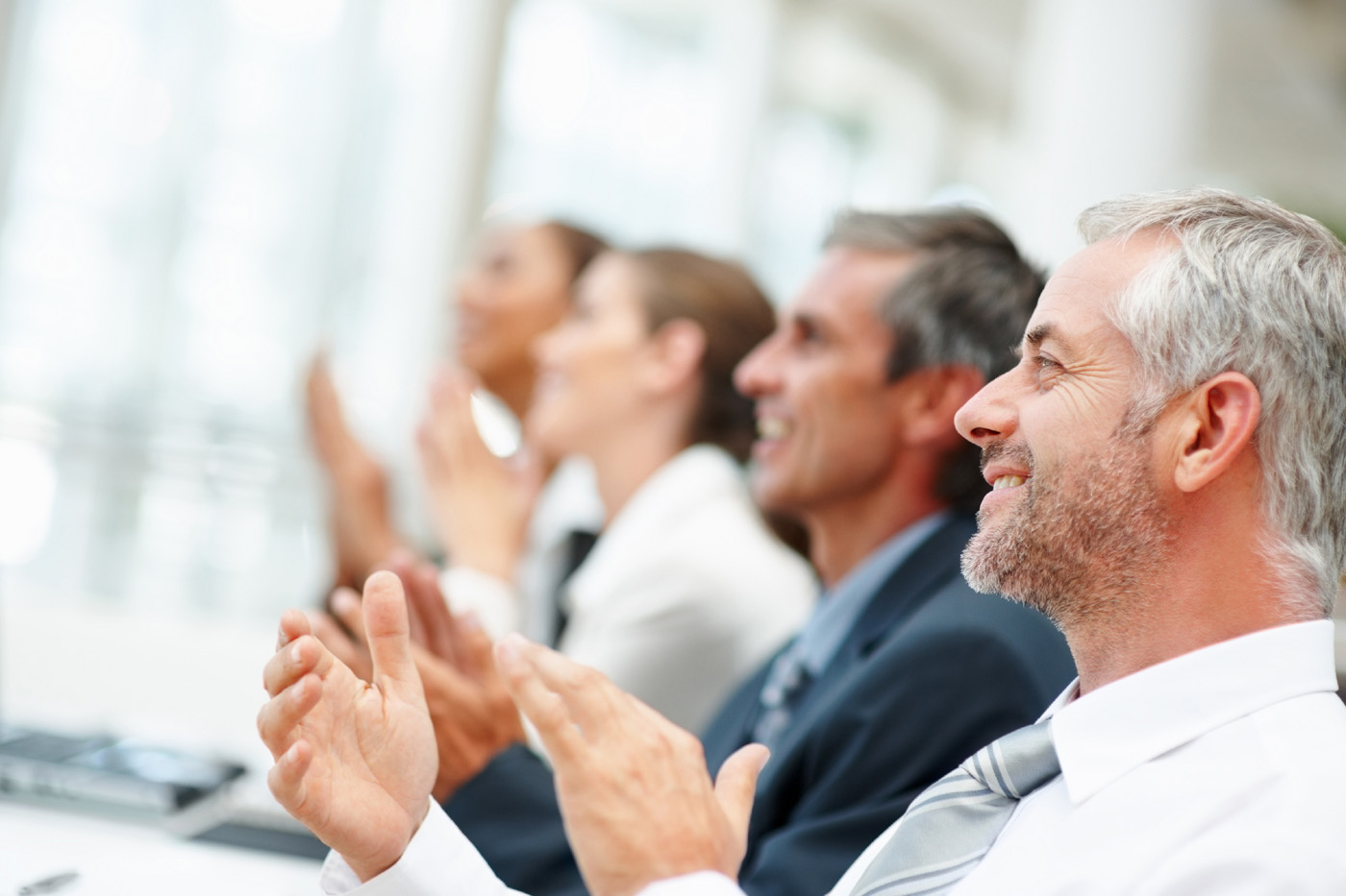 Group of happy business people clapping their hands