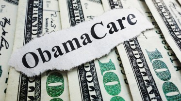 Closeup of an Obamacare newspaper headline on cash