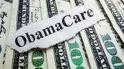 Closeup of an Obamacare newspaper headline on cash