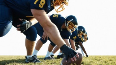 Young team of pro footballers offensive line at practice