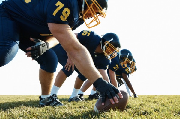 Young team of pro footballers offensive line at practice