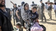 A Syrian Kurdish woman crosses the border between Syria and Turkey at the southeastern town of Suruc in Sanliurfa province on September 23, 2014. The UN refugee agency warned Tuesday that as many as 400,000 people may flee to Turkey from Syria's Kurdish region to escape attacks by the Islamic State group.  (BULENT KILIC/AFP/Getty Images)